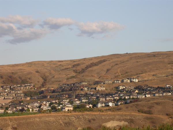 Photo d'une vue de bâtiments dans une vallée de champs bruns.